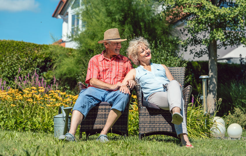 old people in their holiday cottage garden